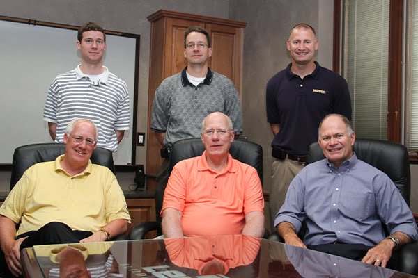 six owners of lensing posing for photo inside conference room